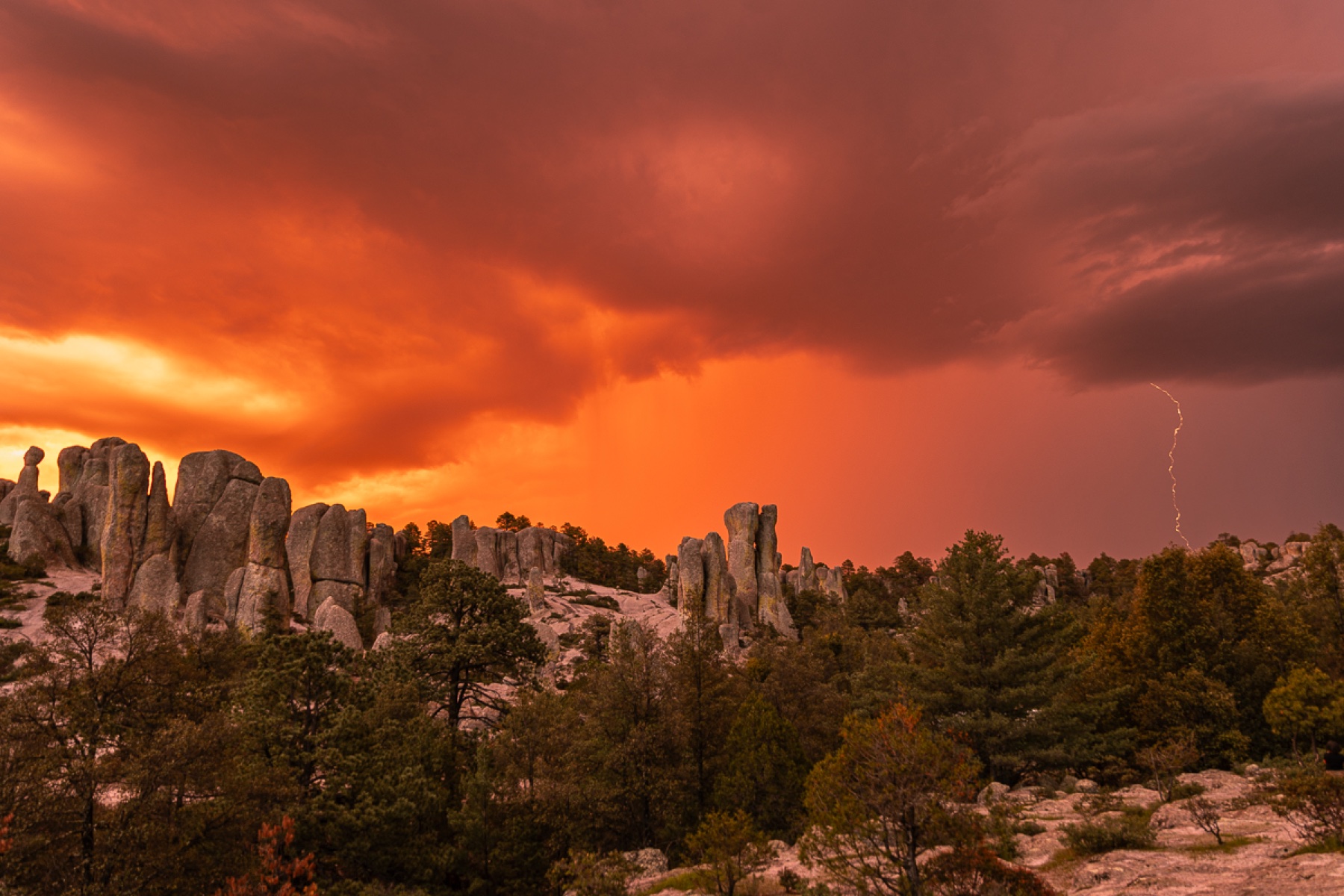 Cielo rojo de tormenta sobre formaciones de roca